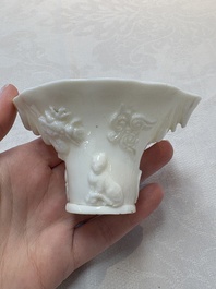 A Chinese Dehua blanc de Chine libation cup, a famille rose cup and two figures, 19th C.
