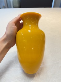 A Chinese Peking yellow glass vase on wooden stand, 19th C.