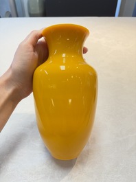 A Chinese Peking yellow glass vase on wooden stand, 19th C.