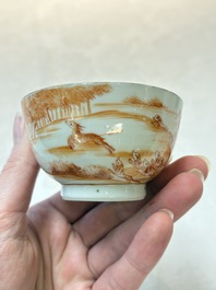 A pair of Chinese iron-red-decorated 'deer hunting' cups and saucers, Qianlong