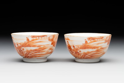 A pair of Chinese iron-red-decorated 'deer hunting' cups and saucers, Qianlong