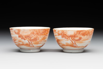 A pair of Chinese iron-red-decorated 'deer hunting' cups and saucers, Qianlong