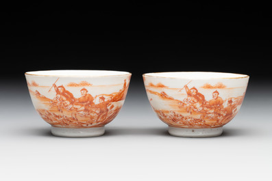 A pair of Chinese iron-red-decorated 'deer hunting' cups and saucers, Qianlong