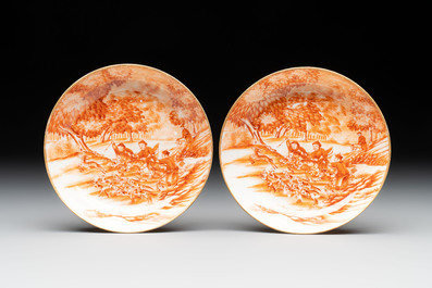 A pair of Chinese iron-red-decorated 'deer hunting' cups and saucers, Qianlong