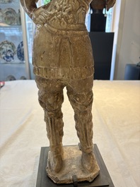 A Chinese stoneware cream-glazed sculpture of a warrior, possibly Tang