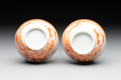 A pair of Chinese iron-red-decorated 'deer hunting' cups and saucers, Qianlong