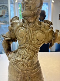 A Chinese stoneware cream-glazed sculpture of a warrior, possibly Tang