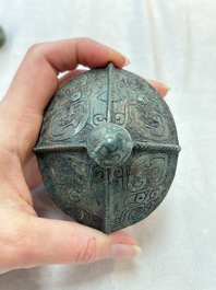 A Chinese archaic bronze food vessel and cover with taotie design, 'zhi 觶', Shang