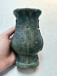 A Chinese archaic bronze food vessel and cover with taotie design, 'zhi 觶', Shang