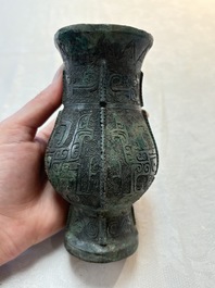 A Chinese archaic bronze food vessel and cover with taotie design, 'zhi 觶', Shang