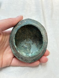 A Chinese archaic bronze food vessel and cover with taotie design, 'zhi 觶', Shang