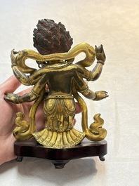 A Sino-Tibetan gilt-bronze figure of White Mahakala on wooden stand, 18th C.