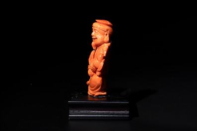 A Japanese red coral sculpture of a fisherman on wooden stand, 19/20th C.
