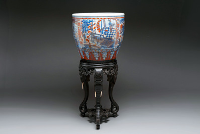A large Chinese European-decorated blue and white fish bowl with narrative design, on a later wooden stand, Kangxi