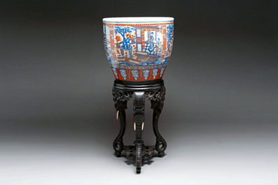 A large Chinese European-decorated blue and white fish bowl with narrative design, on a later wooden stand, Kangxi