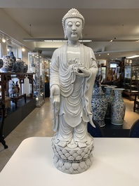 A large Chinese Dehua blanc de Chine figure of Buddha holding a lotus, He Chaozong 何朝宗 and Dehua 德化 mark, 20th C.