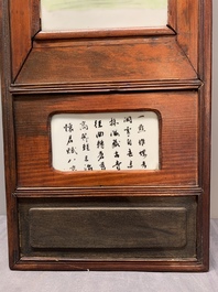 A Chinese carved wooden panel with famille rose plaques in the style of Wang Qi 王琦, dated 1932