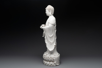 A large Chinese Dehua blanc de Chine figure of Buddha holding a lotus, He Chaozong 何朝宗 and Dehua 德化 mark, 20th C.