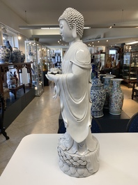 A large Chinese Dehua blanc de Chine figure of Buddha holding a lotus, He Chaozong 何朝宗 and Dehua 德化 mark, 20th C.