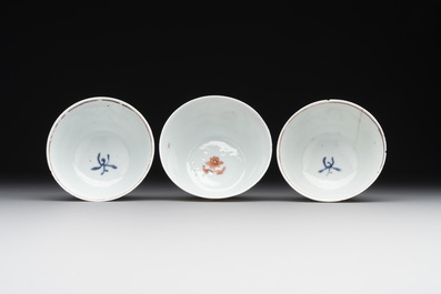 A pair of Chinese polychrome-decorated cups and saucers and an iron-red gilt-decorated cup and saucer, Yongzheng/Qianlong