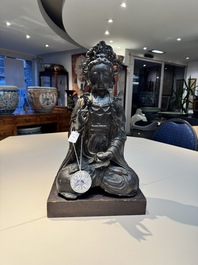 A large Chinese bronze Bodhisattva on wooden stand, Ming