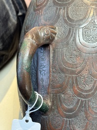 A Chinese archaic bronze inscribed wine vessel with scale design, 'hu 壺', Zhou