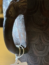 A Chinese archaic bronze inscribed wine vessel with scale design, 'hu 壺', Zhou