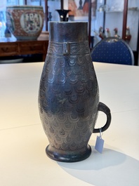 A Chinese archaic bronze inscribed wine vessel with scale design, 'hu 壺', Zhou