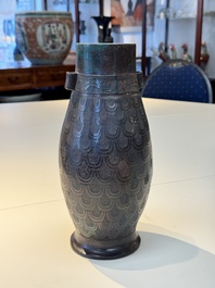 A Chinese archaic bronze inscribed wine vessel with scale design, 'hu 壺', Zhou