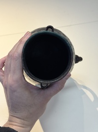 A Chinese archaic bronze inscribed wine vessel with scale design, 'hu 壺', Zhou
