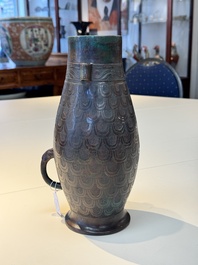A Chinese archaic bronze inscribed wine vessel with scale design, 'hu 壺', Zhou