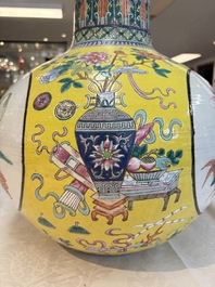 A large Chinese famille rose yellow-ground 'tianqiu ping' vase with flowers and antiquities, 19th C.