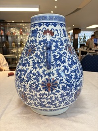 A Chinese blue, white and copper-red 'hu' vase with lotus scrolls, Qianlong mark, 19th C.