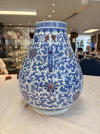 A Chinese blue, white and copper-red 'hu' vase with lotus scrolls, Qianlong mark, 19th C.