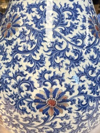 A Chinese blue, white and copper-red 'hu' vase with lotus scrolls, Qianlong mark, 19th C.