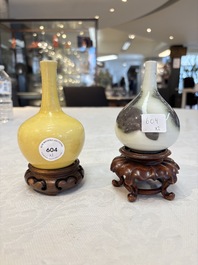A Chinese copper-red 'mythical beasts' vase and a yellow-glazed bottle vase, with two wooden stands, Kangxi and later