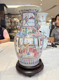 A pair of Chinese famille rose vases with narrative design on wooden stands, 19th C.