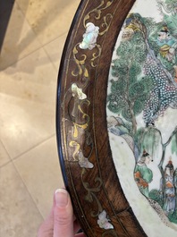 A Chinese mother-of-pearl-inlaid hongmu table with a circular Canton famille verte 'warriors on horseback' plaque, 19th C.
