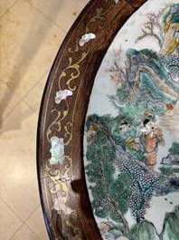 A Chinese mother-of-pearl-inlaid hongmu table with a circular Canton famille verte 'warriors on horseback' plaque, 19th C.