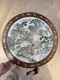 A Chinese mother-of-pearl-inlaid hongmu table with a circular Canton famille verte 'warriors on horseback' plaque, 19th C.