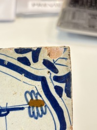 Two blue and white Dutch Delft 'castle' and 'soldier with coloured flame' tiles, 17th C.