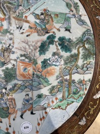A Chinese mother-of-pearl-inlaid hongmu table with a circular Canton famille verte 'warriors on horseback' plaque, 19th C.