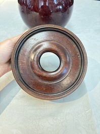 A large Chinese flamb&eacute;-glazed 'yuhuchunping' vase on a wooden stand, 19th C.