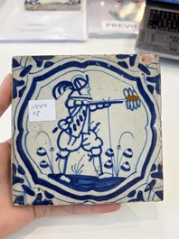 Two blue and white Dutch Delft 'castle' and 'soldier with coloured flame' tiles, 17th C.