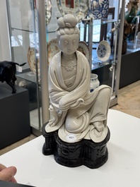 A rare and elegant Chinese Dehua blanc de Chine Guanyin on a wooden stand, Transitional period