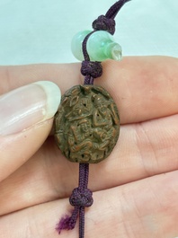 A small Chinese spinach-green jade covered box and two white jade pendants, 18/19th C.