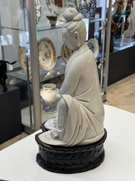A rare and elegant Chinese Dehua blanc de Chine Guanyin on a wooden stand, Transitional period