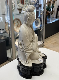A rare and elegant Chinese Dehua blanc de Chine Guanyin on a wooden stand, Transitional period