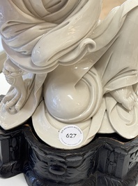 A rare and elegant Chinese Dehua blanc de Chine Guanyin on a wooden stand, Transitional period