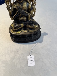 A Tibetan parcel-gilt bronze sculpture of a lama, 20th C.